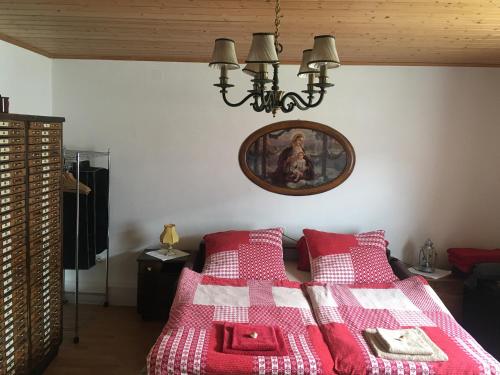 um quarto com uma cama com um cobertor vermelho e branco em Landhaus Hallstättersee em Bad Goisern