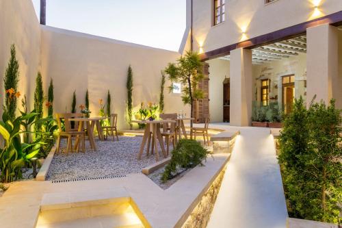 un patio con mesas, sillas y plantas en Aelios Design Hotel, en La Canea