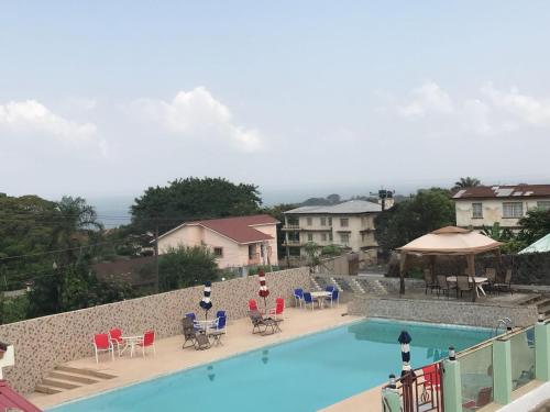 - une vue sur la piscine dotée de chaises et de tables dans l'établissement Hotel Cabenda, à Freetown