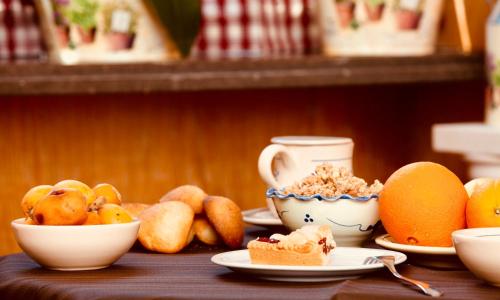 una mesa con platos de comida y cuencos de fruta en Hotel Donatello, en Alberobello