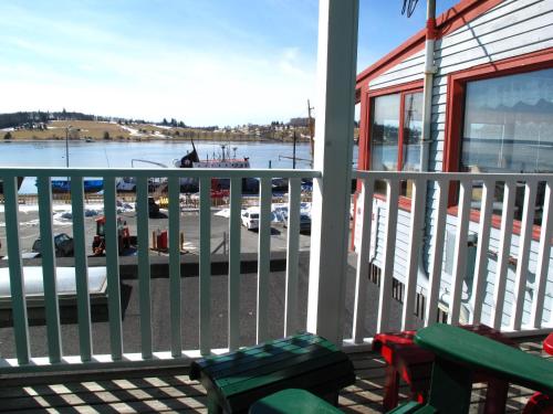 uma varanda com vista para um porto e um barco em Brigantine Inn em Lunenburg