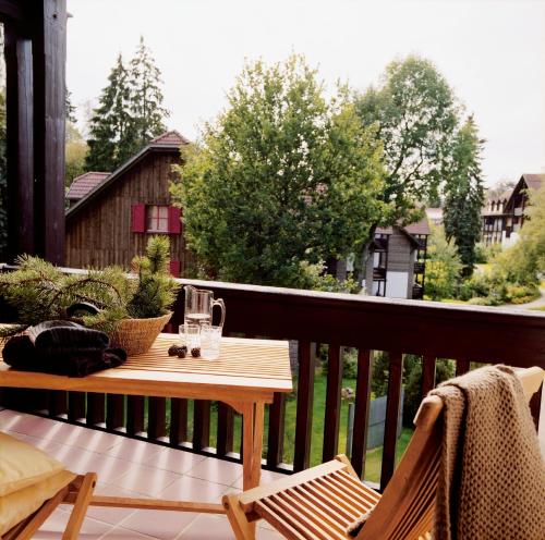 una mesa de madera en un balcón con una mesa en Hapimag Ferienwohnungen Braunlage, en Braunlage