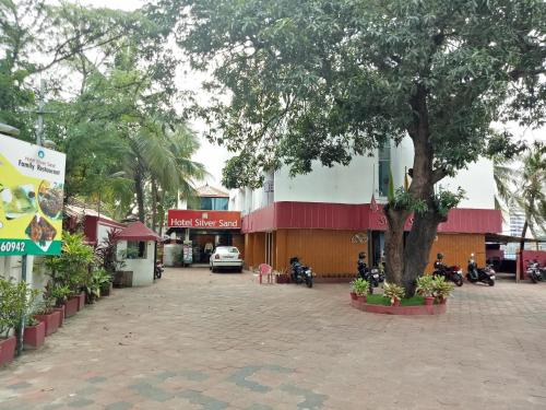 um edifício com uma árvore no meio de uma rua em Hotel Silver Sand em Trivandrum