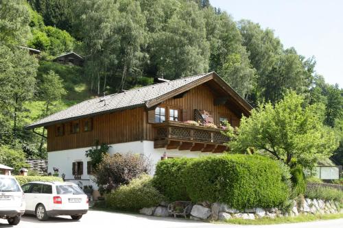 una casa de madera con coches aparcados frente a ella en Haus Südblick, en Zell am See