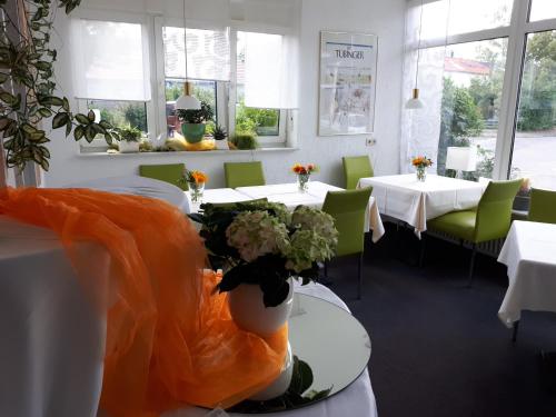 une salle à manger avec des tables, des chaises et des fleurs dans l'établissement Hotel Garni Sand, à Tübingen