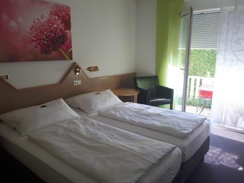 - une chambre avec deux lits, une chaise et une fenêtre dans l'établissement Hotel Garni Sand, à Tübingen