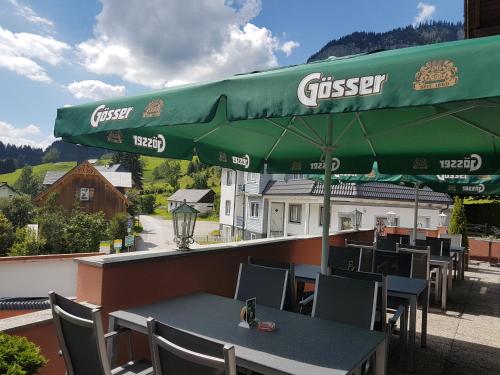 una sombrilla verde sobre una mesa en Hotel Tauplitzerhof, en Tauplitz