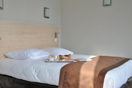 - un lit avec un plateau de nourriture dans l'établissement Hotel Foch Nancy Gare, à Nancy