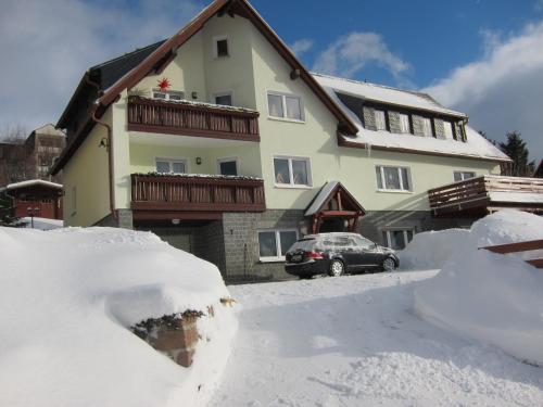 een huis met veel sneeuw ervoor bij Ferienwohnungen Oberwiesenthal in Kurort Oberwiesenthal