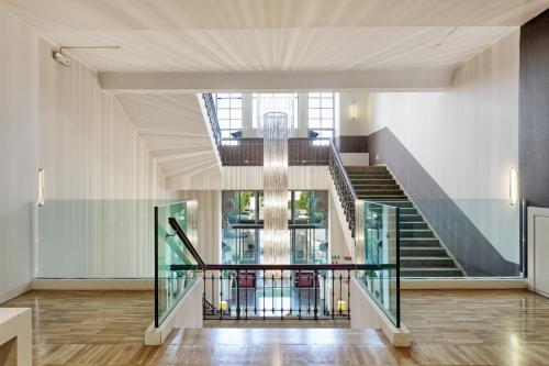 un escalier avec rampe en verre dans un bâtiment dans l'établissement Italiana Hotels Milan Rho Fair, à Rho