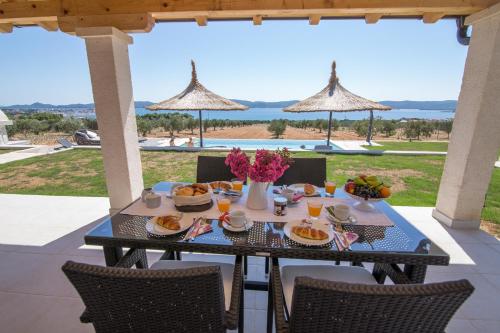 uma mesa com comida e flores num pátio em Estate Villa Duo em Biograd na Moru