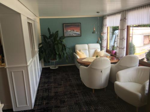 a living room with white chairs and a table at Hotel Katharina Garni in Tübingen