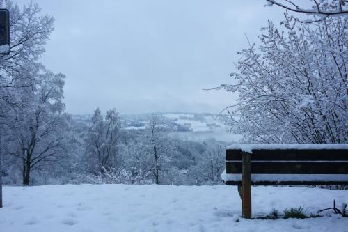 una panchina del parco coperta di neve con vista di Belle vue a Malmedy