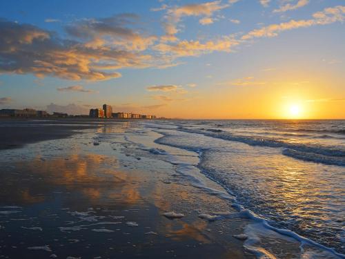 einen Strand mit Sonnenuntergang in der Ferne in der Unterkunft Hotel Rubens in Ostende