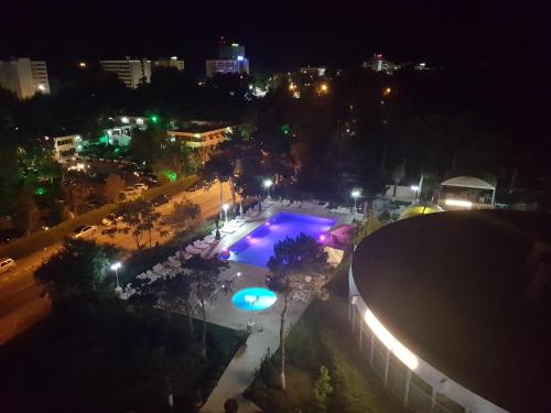 a city at night with a swimming pool at Hotel Scoica in Jupiter