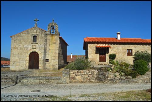 een oude stenen kerk met een kruis erop bij Castelo Cottages in Castelo Novo