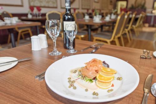 - une assiette de nourriture sur une table avec une bouteille de vin dans l'établissement Salutation Hotel, à Perth