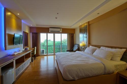 A bed or beds in a room at Kitlada Hotel Udonthani