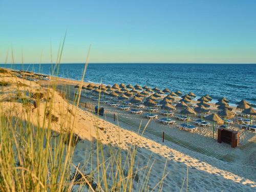 - une plage avec un bouquet de parasols et l'océan dans l'établissement Hotel Quinta do Lago, à Quinta do Lago