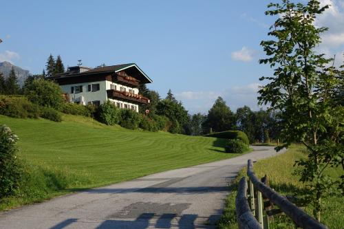 ein Haus auf einem Hügel neben einer Straße in der Unterkunft Gästehaus Zum Tauern in Radstadt