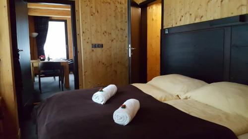 una camera da letto con 2 asciugamani bianchi su un letto di Krakonošova Dílna "WOODHAUS" a Špindlerův Mlýn