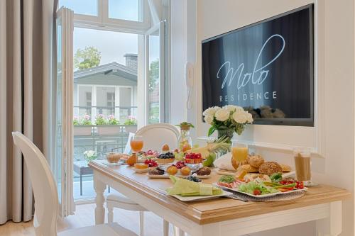 una mesa con comida en el comedor en Apartamenty Molo Residence, en Sopot