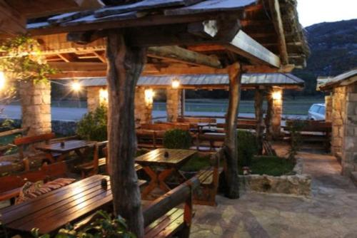 un restaurant avec bancs et tables en bois et vue sur l'océan dans l'établissement Stara Hercegovina, à Trebinje