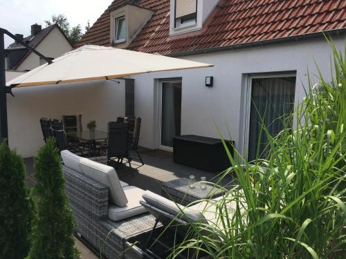 un patio con sofá y sombrilla en Ferienhaus Birkenweg, en Erfurt