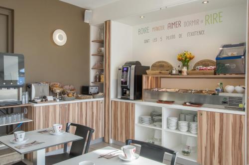 una sala da pranzo con tavolo e una caffetteria di Cit'Hotel Imperial a Sète