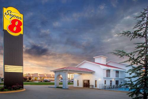 - un grand bâtiment blanc avec un panneau devant dans l'établissement Super 8 by Wyndham Springdale AR, à Springdale