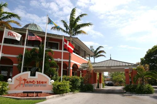 un hôtel avec drapeaux devant un bâtiment dans l'établissement The Marlin at Taino Beach Resort, à Freeport