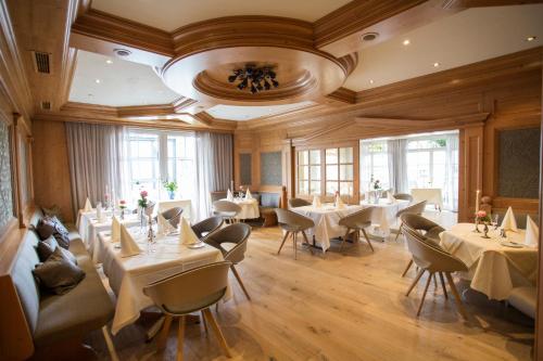 een restaurant met witte tafels, stoelen en ramen bij Hotel Sauerländer Hof in Hallenberg