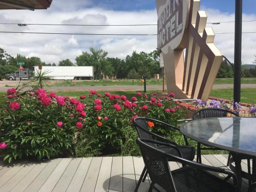 un patio con mesa, sillas y flores en Travel Inn Motel, en Canon City