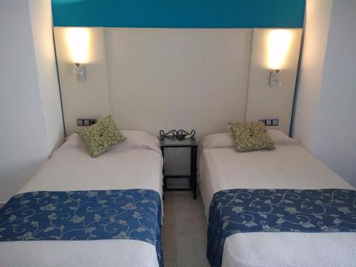 Zimmer mit 2 Betten und einem Tisch in der Unterkunft Hotel Nuevo Ara in Cáceres