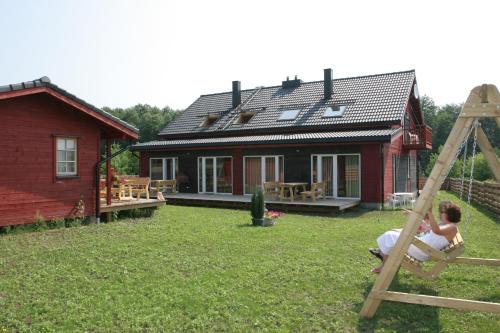 una mujer jugando en un columpio en el patio de una casa en Love Island Guesthouse, en Druskininkai