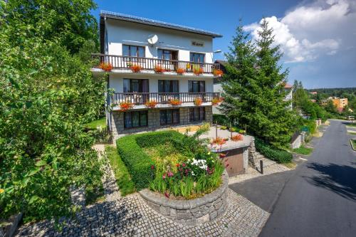 een huis met een balkon en bloemen in een tuin bij Szum i Las in Szklarska Poręba