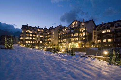 una fila di edifici nella neve di notte di Premier Luxury Mountain Resort a Bansko