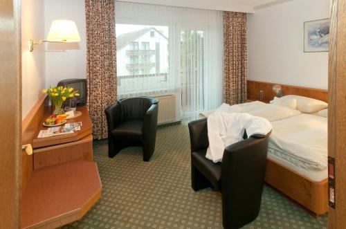 Cette chambre comprend un lit, un bureau et des chaises. dans l'établissement Hotel Zum Goldenen Hirsch, à Bad Bevensen