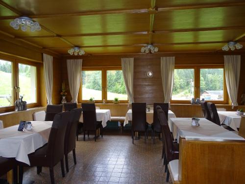 a dining room with tables and chairs and windows at Apart Tyrol in Umhausen