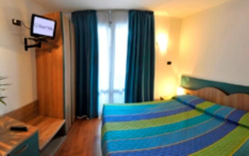 een slaapkamer met een blauw en groen bed en een raam bij Hotel Vela in Trento