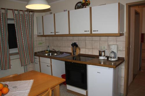 a small kitchen with white cabinets and a sink at Ferienwohnungen Goldbach 1. Stock in Regensburg