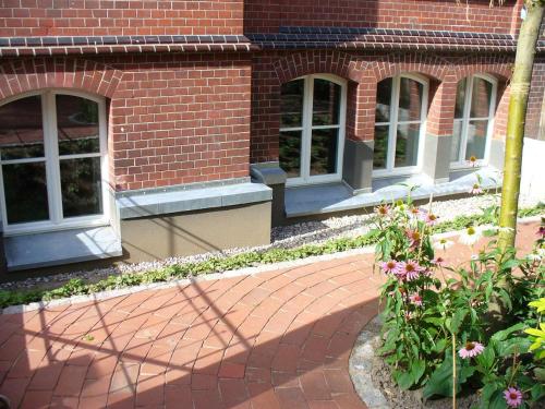 a brick building with windows and flowers in front of it at Ferienwohnung Riedner in Lüneburg