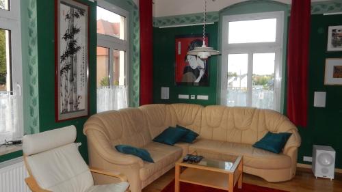 a living room with a white couch and green walls at Ferienwohnung Freiberg, Chemnitzer Straße in Freiberg