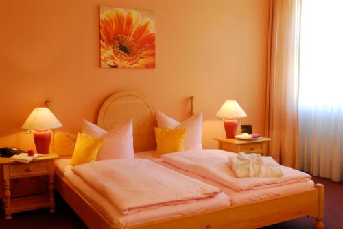 a bedroom with a bed with white sheets and yellow pillows at Kurhotel Fürstenhof by David in Blankenburg