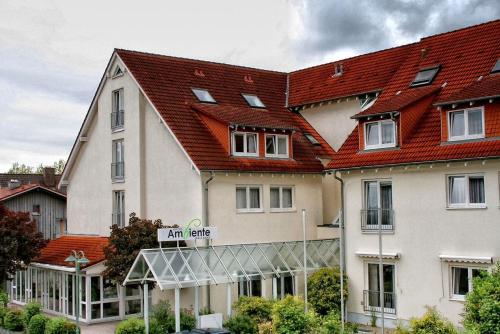 a large white building with a red roof at Hotel Ambiente Walldorf in Walldorf