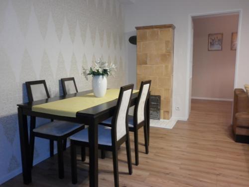 a dining room table with chairs and a vase of flowers at Staszica Centrum in Lublin