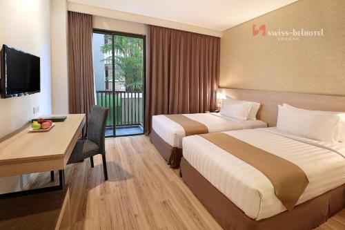 Rúm í herbergi á Swiss-Belhotel Sorong