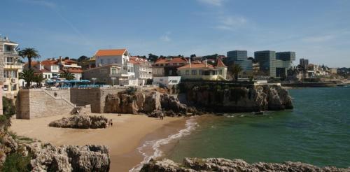 een uitzicht op een strand met huizen en het water bij Suites Guest House in Cascais