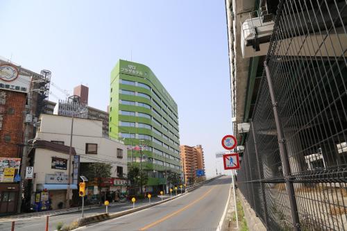 una strada vuota in una città con edifici alti di Osaka Moriguchi Plaza Hotel ad Osaka