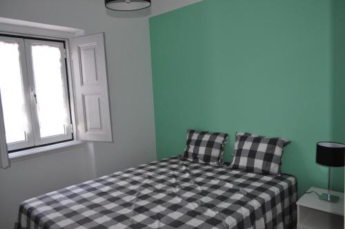 a bedroom with a black and white checkered bed at A Casa do Mestre in Évora